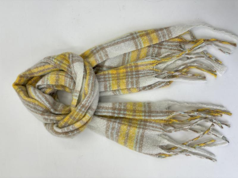 Soft plaid scarf in yellow, beige, and cream with fringe ends, loosely knotted on a white background