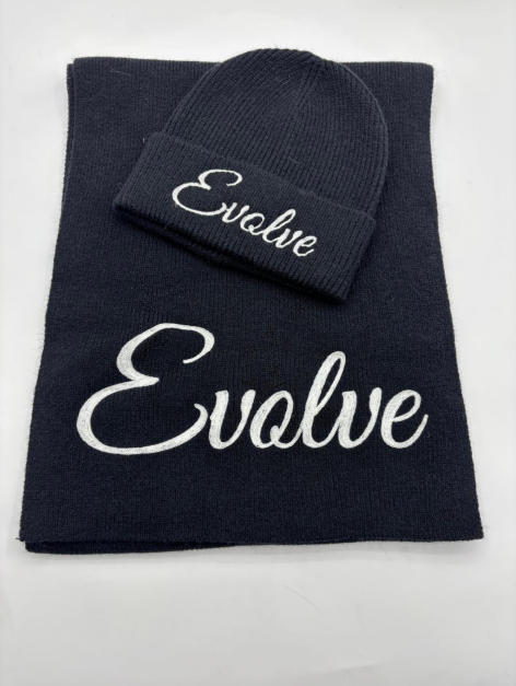 Navy blue knit beanie hat and matching scarf set with white cursive script embroidery on white background