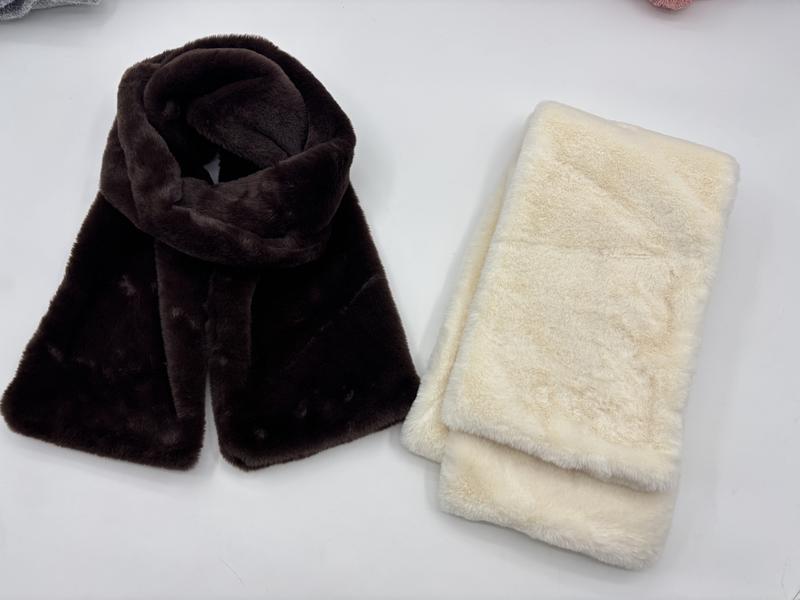 Two faux fur plush scarves side by side, one dark chocolate brown draped and one cream white folded, soft fluffy texture