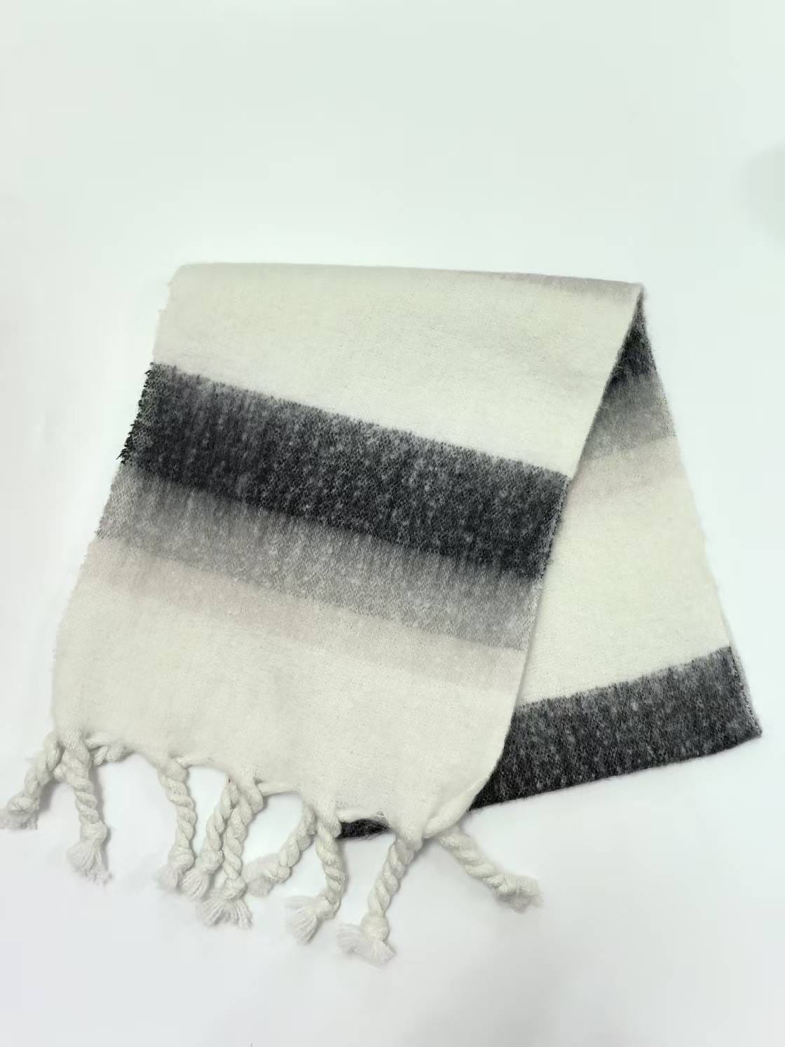 Folded ivory and charcoal gray striped brushed scarf with twisted rope fringe ends on white background