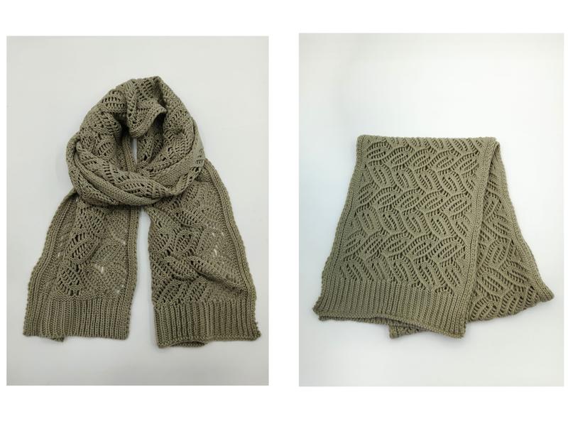 Sage green knit scarf with open lace diamond pattern and ribbed edges, shown draped and folded on white background