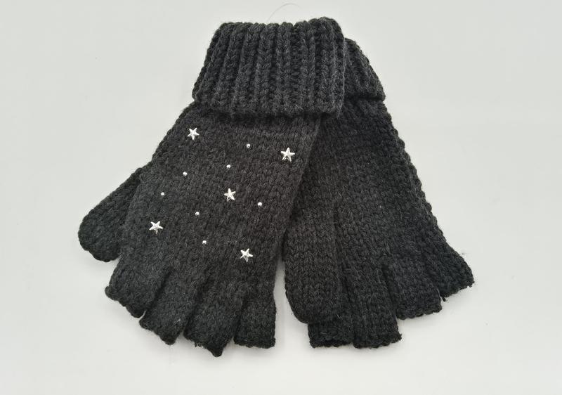 Pair of dark grey chunky knit fingerless gloves decorated with silver star studs and crystal embellishments on a white background
