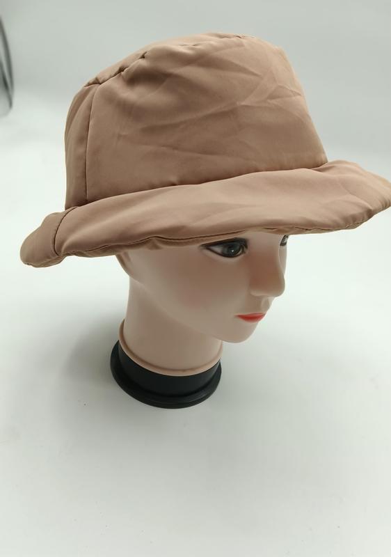 Beige quilted puffer bucket hat displayed on a mannequin head, showing wide brim and padded nylon fabric construction