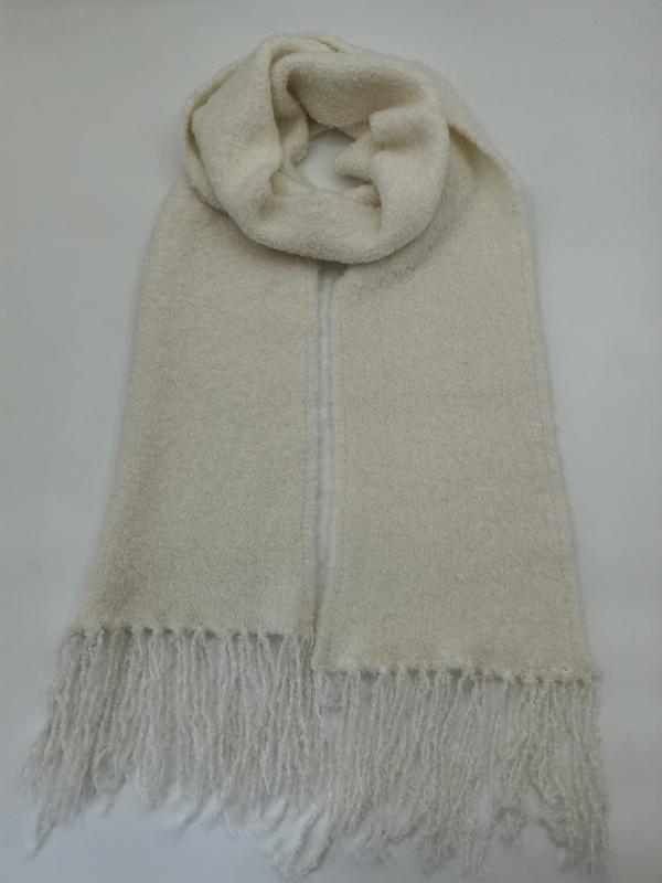 Ivory cream boucle wool blend scarf with fringe ends, looped and laid flat on white background