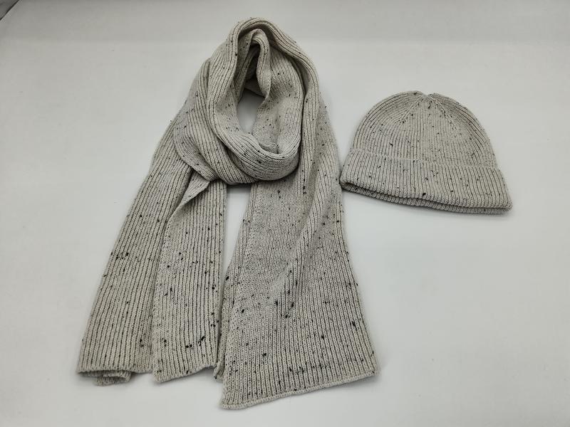 Light grey ribbed knit scarf and matching beanie hat set with dark fleck speckle pattern on white background