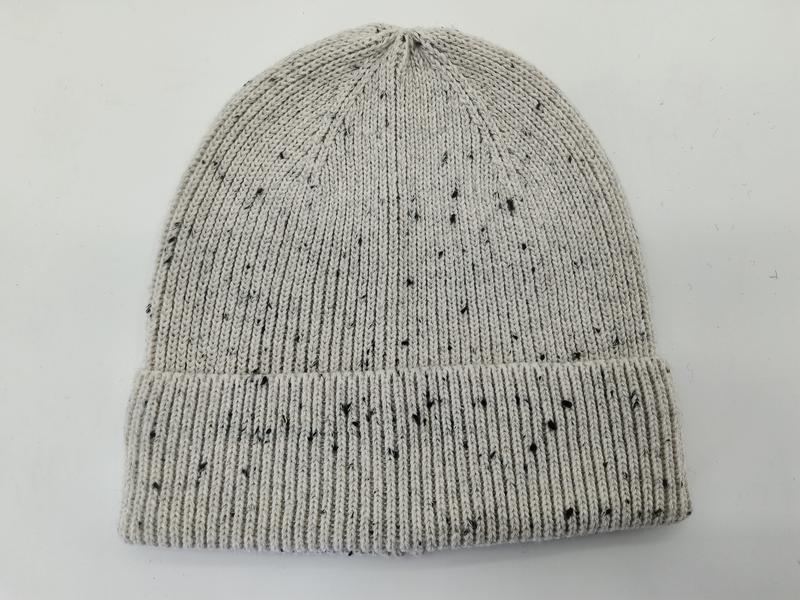Light grey knit beanie hat with black speckle fleck pattern and folded ribbed cuff, laid flat on white background