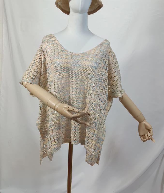 Beige multicolor open-knit crochet poncho top with short sleeves displayed on a mannequin with wooden articulated arms