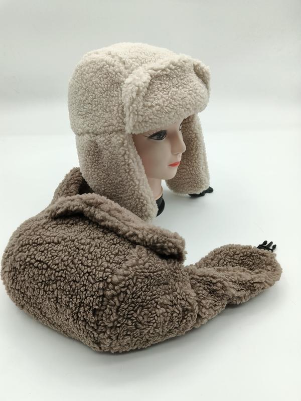 Cream and taupe sherpa fleece trapper ushanka hat with ear flaps displayed on mannequin head with matching hat below