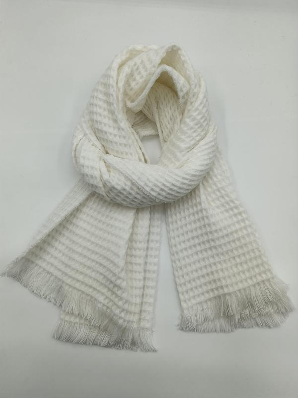 Cream ivory waffle textured scarf with fringe trim, loosely knotted and displayed flat on white background