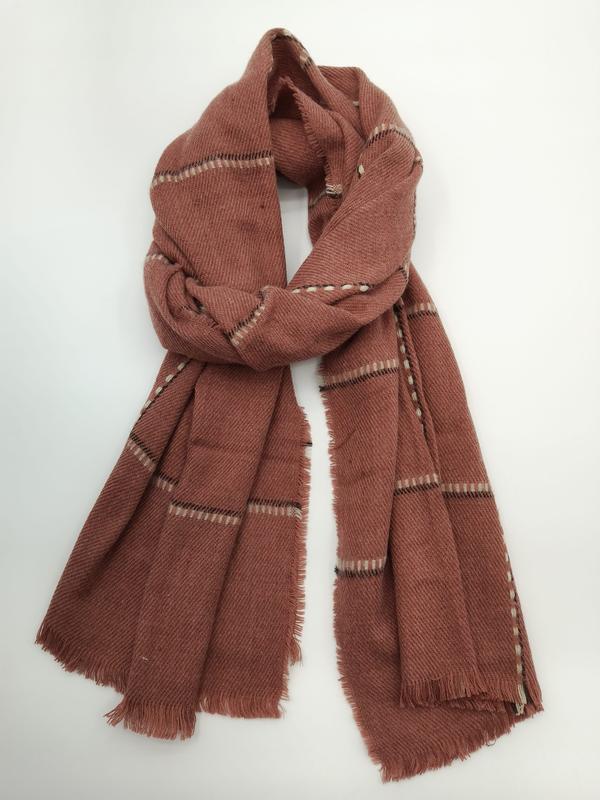 Dusty rose plaid wool blend scarf with cream and black stripes, fringe edges, loosely knotted on white background