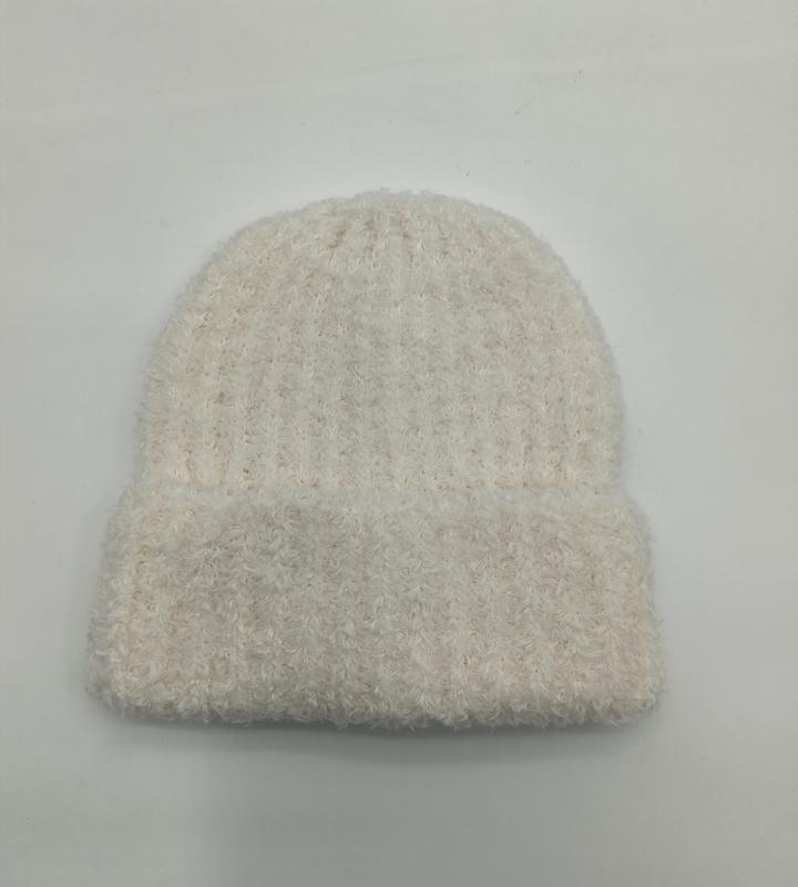 Cream white fuzzy ribbed knit beanie hat laid flat on white background, soft fluffy textured winter slouch cap