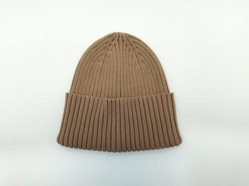 Camel tan chunky ribbed knit cuffed beanie hat laid flat on white background, showing textured stitch detail