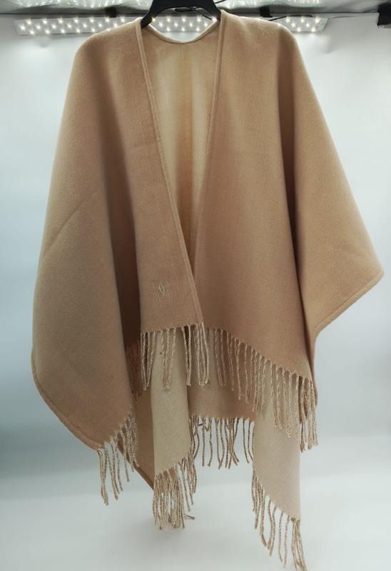 Camel beige open-front wool cape poncho with tassel fringe hem and embroidered monogram logo on hanger