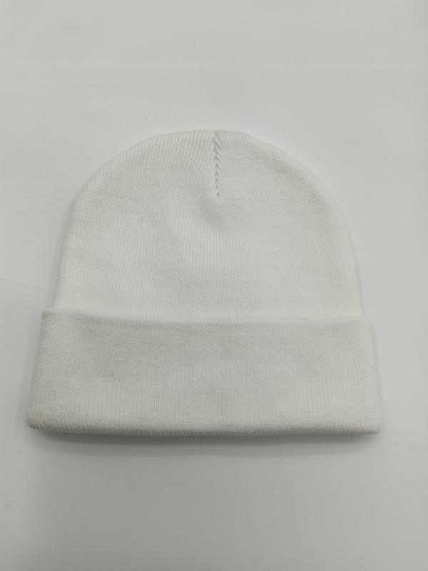 Plain white ribbed knit cuffed beanie hat laid flat on white surface, showing folded brim and seamed crown