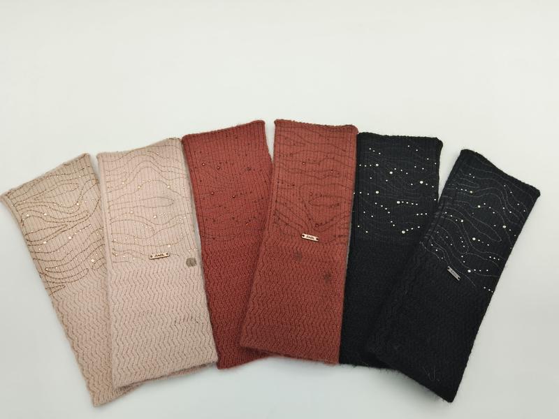Six knit headbands fanned out in pink, dusty rose, rust, terracotta, charcoal and black with sequin and wave embroidery details