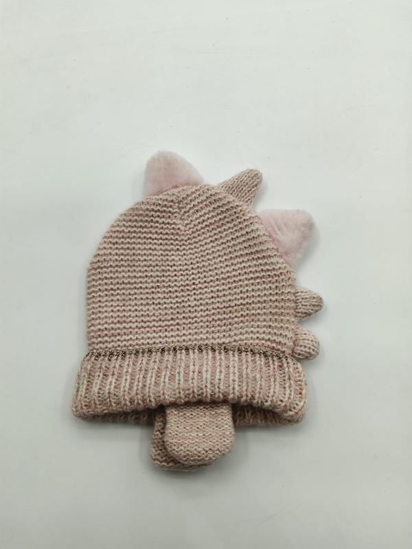 Pink knitted baby winter hat with fluffy pom-pom unicorn ears and matching mittens set laid flat on white background
