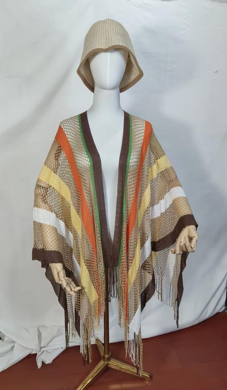 Mannequin wearing a brown orange yellow striped open mesh net poncho with long fringe and matching beige woven bucket hat