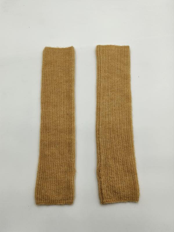 Pair of mustard yellow ribbed knit fingerless arm warmers laid flat on white background