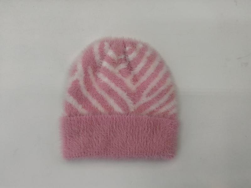 Pink fluffy knit beanie hat with white zebra stripe pattern and folded cuff, laid flat on white background