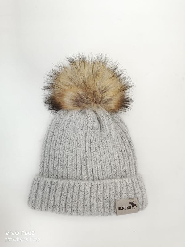 Light gray chunky ribbed knit winter beanie hat with large faux fur pom pom on white background