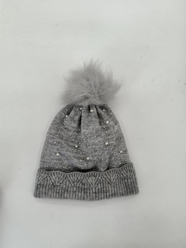 Grey knitted winter beanie hat with scattered pearl and rhinestone details, cable knit cuff, and fluffy faux fur pompom on top