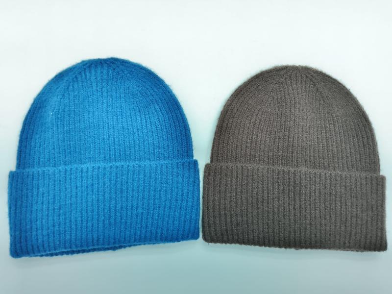 Two ribbed knit cuffed beanies side by side, one in bright blue and one in taupe brown, on white background