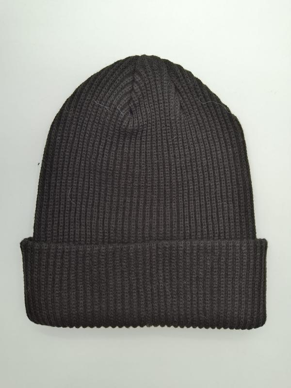 Dark charcoal ribbed knit beanie hat with folded cuff brim, laid flat on white background