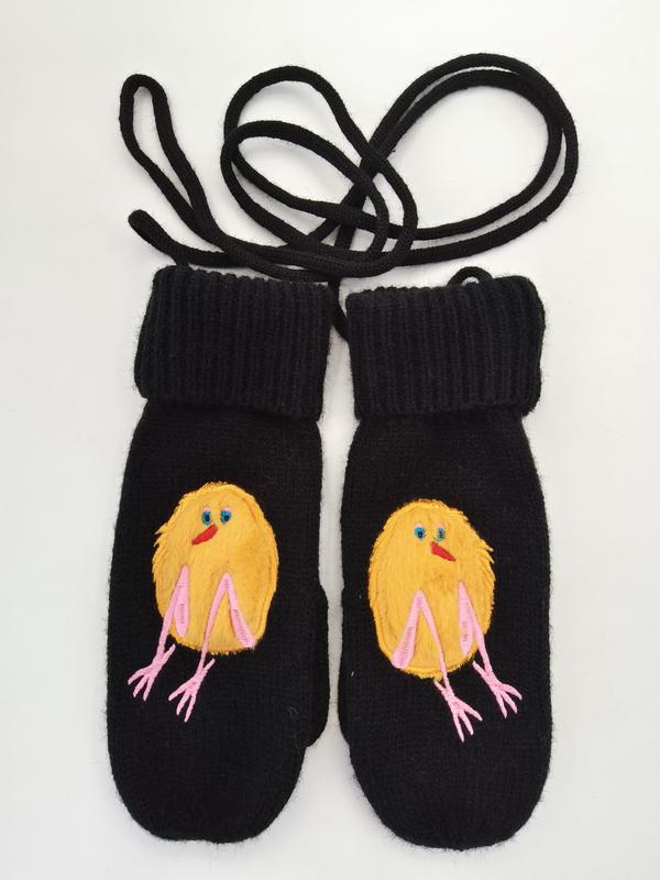 Pair of black wool knit mittens with embroidered yellow baby chick design and pink legs, connected by black neck cord