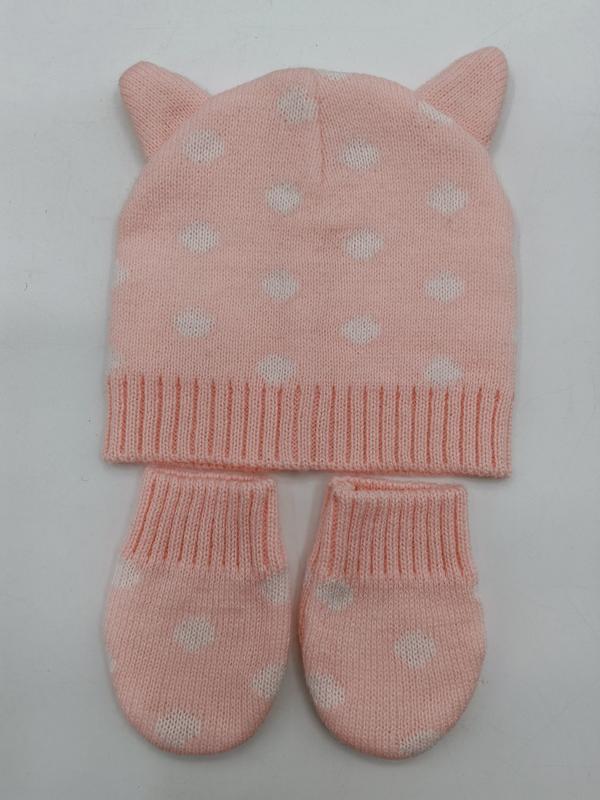 Pink knitted baby beanie hat with cat ears and white heart pattern, paired with matching mittens set on white background