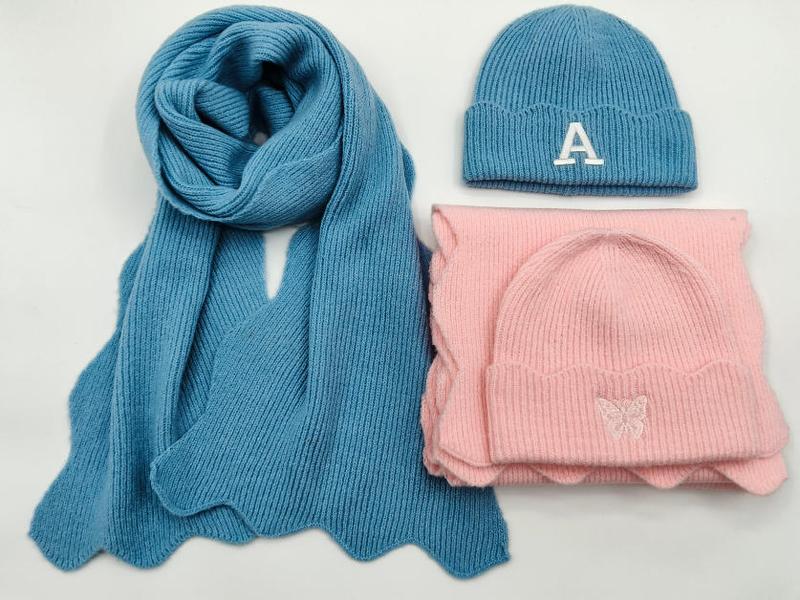Blue knit scarf with letter A embroidered beanie and pink butterfly embroidered beanie hat scarf set on white background