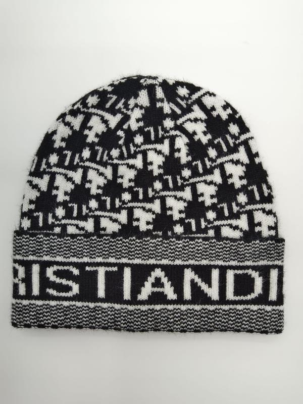 Black and white houndstooth patterned knit beanie with ribbed logo cuff band, laid flat on white background