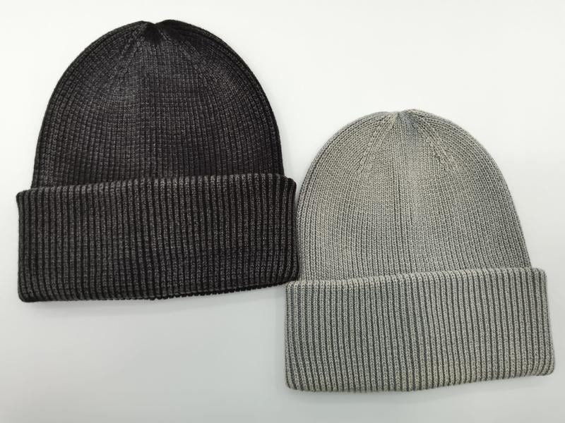 Two ribbed knit cuffed beanie hats side by side, one charcoal dark grey and one light grey, on white background