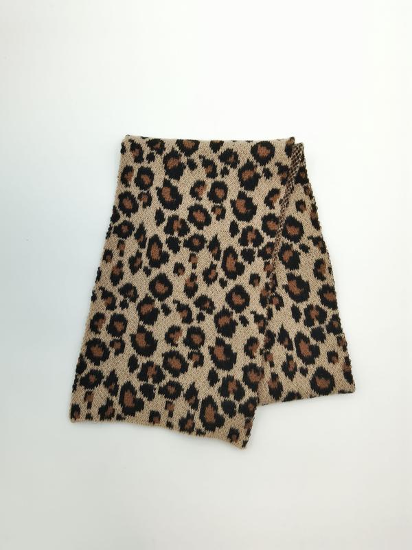Folded beige and brown leopard print knitted neck warmer snood scarf on white background