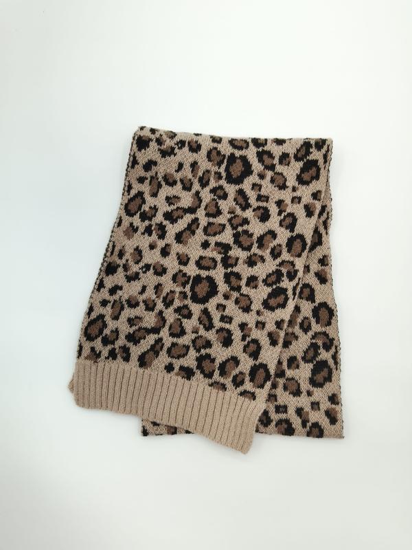 Folded beige and black leopard print knitted scarf with ribbed cuffs on white background