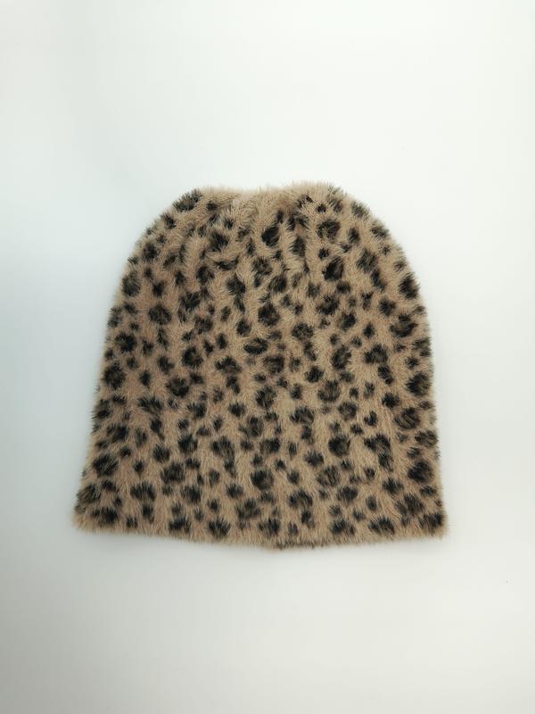 Flat lay of a tan and dark brown leopard print fuzzy knit beanie hat on a white background