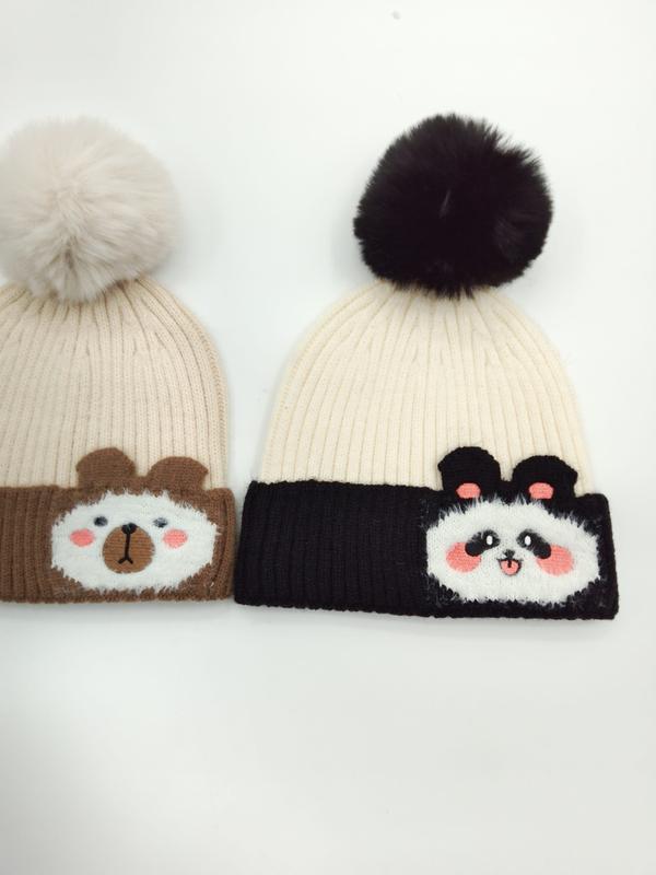Two ribbed knit pom-pom beanies with bear and panda appliqué patches, beige with cream pom and white with black pom